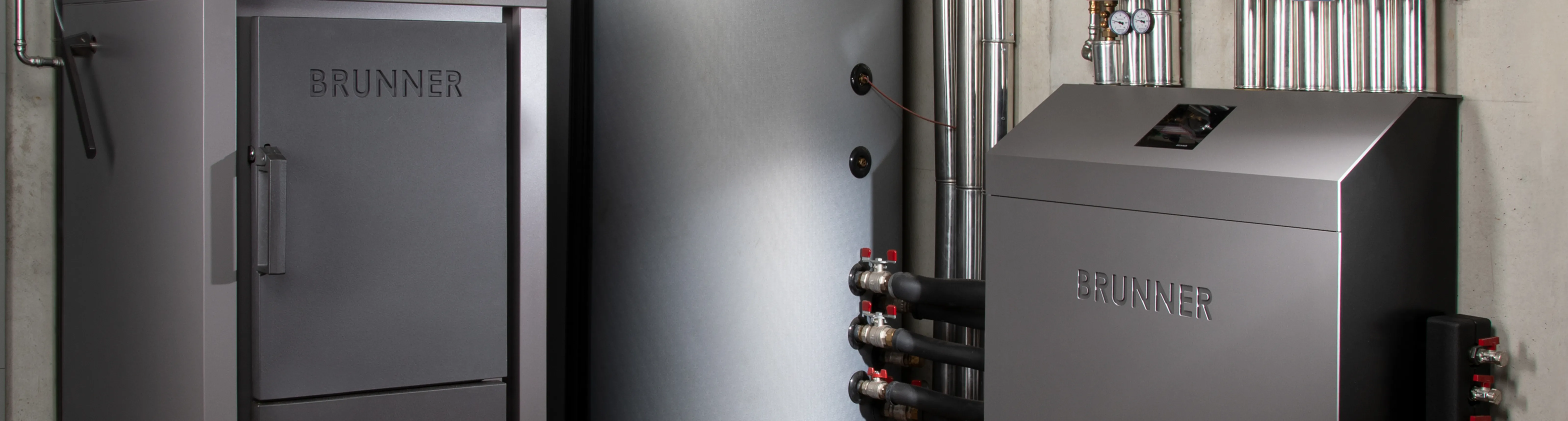 Ein moderner Heizungsraum mit einem leistungsstarken Holzvergaser-Kessel der Marke BRUNNER in einem eleganten, anthrazitfarbenen Design. 