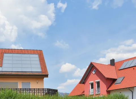 Häuser mit Solarthermie-Modulen auf den Dächern.