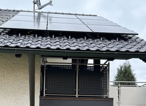 Die Photovoltaikanlage auf dem Schrägdach eines Hauses ist prominent platziert und deckt mehrere Dachziegelreihen ab. 