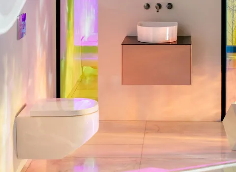 Das stilvolle Badezimmer zeigt ein WC der Laufen Sonar Kollektion, montiert an einer hellen Wand mit sanftem Farbspiel durch Lichteffekte.