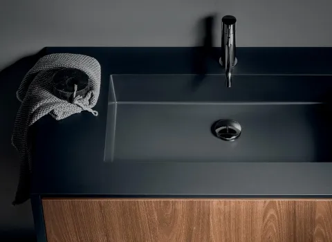 Moderner Waschtisch Iks Full von Stocco mit dunkelgrauer Platte, integriertem Becken und Holzfront in warmer Eichenoptik.