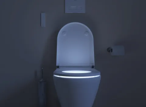 Dusch-WC SensoWash D-Neo mit LED-Nachtlicht in dunkler Badezimmerumgebung.