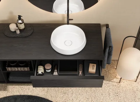 Waschtisch aus der Kollektion Uomo des Herstellers burgbad in der Farbe Eiche Natur Nachtschwarz mit offener Schublade.