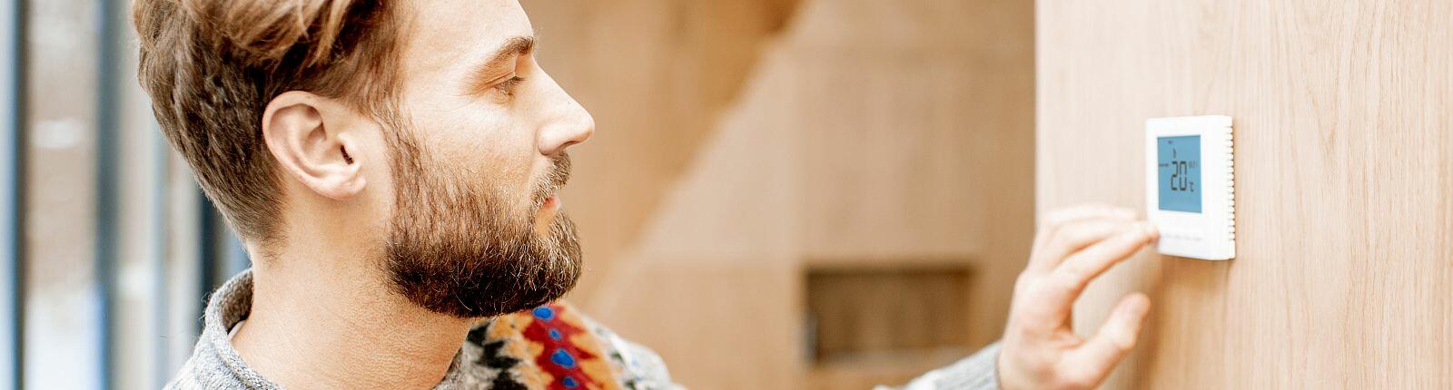 Lizenziert DATEI NR.:  239478202  Vorschau für Zuschneiden  Ähnliche suchen ABMESSUNGEN 7146 x 4769px DATEITYP JPEG KATEGORIE Menschen LIZENZTYP Standard oder Erweitert Man in sweater feeling cold adjusting room temperature with electronic thermostat at home